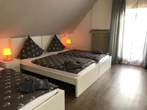 1 dormitorio con 2 camas con almohadas negras en Vina am ring Apartment, en Mannebach