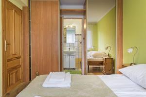 a bedroom with a bed and a bathroom with a sink at Apartament Litoral Jurata in Jurata