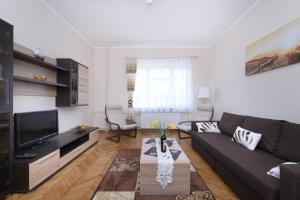 een woonkamer met een bank en een tv bij Apartamenty Mirada in Gdynia