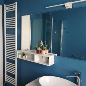 bagno blu con lavandino e specchio di Suite Manin a Treviso