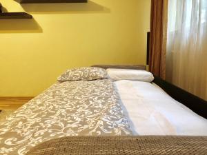 a bed sitting in a room with a pillow on it at Cozy and Clean Apartment, near National Arena in Bucharest