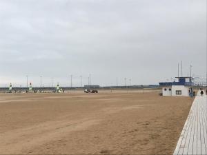 ein Strand mit einem Gebäude und Flugzeugen darauf in der Unterkunft Riva Bella in Ouistreham