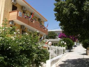 a building with a balcony with flowers on it at Katerina Hotel in Tolo