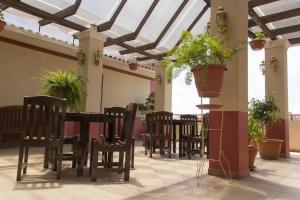 comedor con mesa, sillas y macetas en City Hotel, en Cochabamba