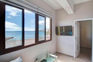 Pokój z telewizorem i oknem z widokiem na ocean w obiekcie Sonias City Beach w mieście Santa Cruz de la Palma