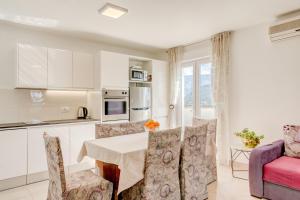 - une cuisine et une salle à manger avec une table et des chaises dans l'établissement Apartments Jokica, à Split