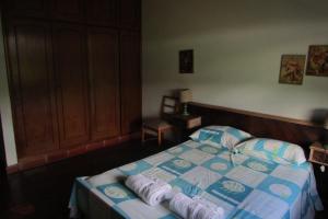 a bedroom with a bed with towels on it at Sitio Prainha in Guararema