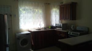 a kitchen with a sink and a washing machine at Wilks Villa in Knowles +3 photos