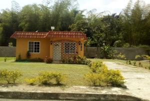 a small yellow house in a yard at Wilks Villa in Knowles