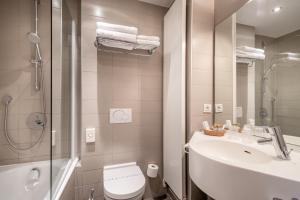 
a bathroom with a toilet, sink, and shower at Hotel Albert I in Bruges
