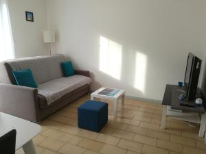 un soggiorno con un divano e un tavolo di Centre Ville Saint-Martin a Perpignano