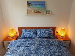 a bedroom with a blue bed with two lamps at EvaMaria apartments in Poreč