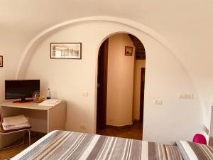 a room with a bed and a desk with a computer at Casa Isetta & La Casetta degli Dei in Massa Lubrense
