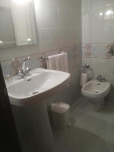 a white bathroom with a sink and a toilet at Casa Luar in Odeceixe