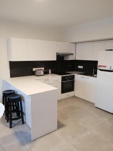 a kitchen with white cabinets and black appliances at Egkomi Luxury Spacious apartment in Yukarı Lakatamya