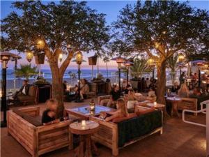 a group of people sitting on couches in a restaurant at Steps to the Sand and Main Street 4BR in Huntington Beach