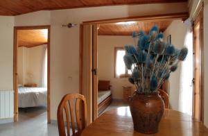 a vase on a table with blue flowers in it at Ca de Garbot in Durro