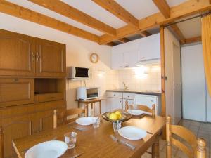 a kitchen with a wooden table with plates on it at Holiday Home Jardins de l'Océan-1 by Interhome in Saint-Georges-de-Didonne