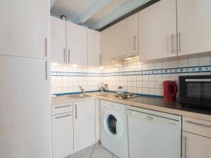 a kitchen with white cabinets and a washing machine at Holiday Home Jardins de l'Océan-3 by Interhome in Saint-Georges-de-Didonne