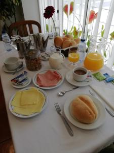 uma mesa coberta com pratos de comida e sumo de laranja em Residencial D. João III em Ponta Delgada