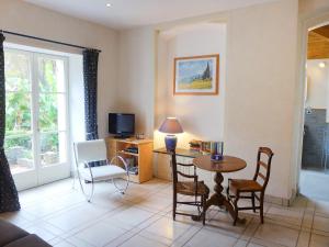 a living room with a table and chairs and a television at Holiday Home Le chant des milans by Interhome in Ondres