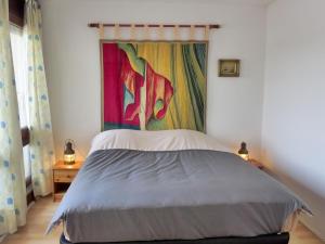 a bedroom with a bed with a painting on the wall at Apartment mille sabords-6 by Interhome in Capbreton