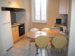 a kitchen with a table and four chairs in it at Holiday Home Villa du Lac by Interhome in Beaune