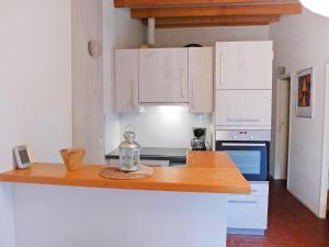 a kitchen with white cabinets and a wooden counter top at Holiday Home Les Palombes-3 by Interhome in Lacanau-Océan