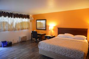 a hotel room with a bed and a desk at Glass Slipper Inn - Stanford Palo Alto in Palo Alto +18 photos