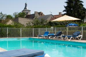 a swimming pool with chairs and an umbrella at Logis Hôtel du Pont Neuf in Le Veurdre