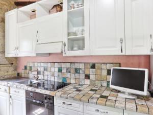 a kitchen with white cabinets and a computer on the counter at Holiday Home Sweet Maremma by Interhome in SantʼAntonio