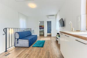 a living room with a blue chair and a sink at St.Lucija in Split