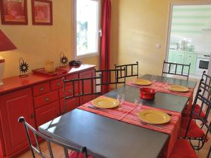 uma sala de jantar com duas mesas e cadeiras e uma cozinha em Holiday Home Clos Saint Joseph by Interhome em Lagnes