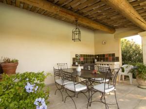 eine Terrasse mit einem Tisch und Stühlen auf einer Terrasse in der Unterkunft Holiday Home La Fabrique by Interhome in Villelaure