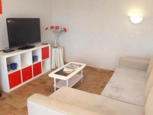 a living room with a couch and a tv at Holiday Home Roumagnac by Interhome in Cavalaire-sur-Mer
