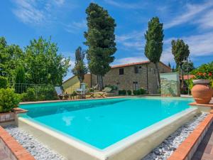 a swimming pool in front of a house with trees at Apartment Il Borghetto-3 by Interhome in Montecarelli
