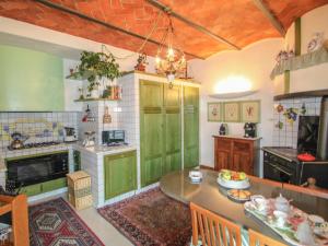 PiteccioにあるVilla Villa Campo del Mulino by Interhomeのキッチン(緑のキャビネット、テーブル付)