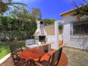 d'une terrasse avec une table et un poêle à bois. dans l'établissement Holiday Home Lucie by Interhome, à Balcon del Mar