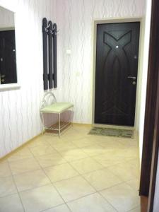 ヴィーシュホロドにあるUpTown-Квартираのタイルフロアの客室で、ドアとベンチが備わります。