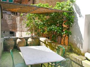 un tavolo e sedie in un patio con piante di Apartment San Girolamo by Interhome a San Gimignano