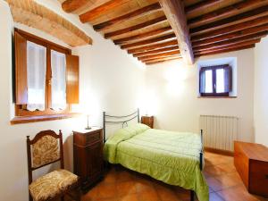 a bedroom with a bed and a desk and windows at Apartment Le Buche-5 by Interhome in Monsanto