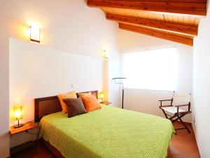 a bedroom with a green bed with two lamps and a chair at Holiday Home Rua 5 de Outubro by Interhome in Lagos