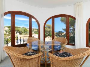 Balcon del MarにあるHoliday Home Balcon al Mar by Interhomeのガラスのテーブルと椅子、窓のあるバルコニー