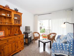 ein Wohnzimmer mit einem Sofa und einem TV in der Unterkunft Apartment Sant Pol by Interhome in San Pol de Mar