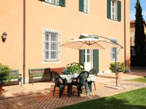 a table and chairs with an umbrella in front of a building at Villa Paolotti by Interhome in Bettona