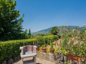 kamienna ławka w ogrodzie z kwiatami i roślinami w obiekcie Holiday Home Il Fienile del Colle by Interhome w mieście San Gennaro