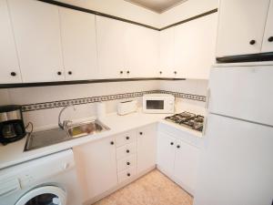kuchnia z białymi szafkami i białą lodówką w obiekcie Apartment Edificio Belen V by Interhome w mieście Torrevieja
