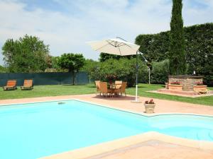 a pool with an umbrella and a table and chairs at Villa Paolotti by Interhome in Bettona