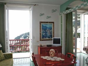 a living room with a table and a television at Locazione Turistica Caleidoscopio in Amalfi