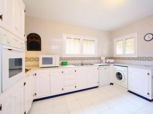 モライラにあるHoliday Home Isla Bonita by Interhomeのキッチン(白いキャビネット、洗濯機、乾燥機付)